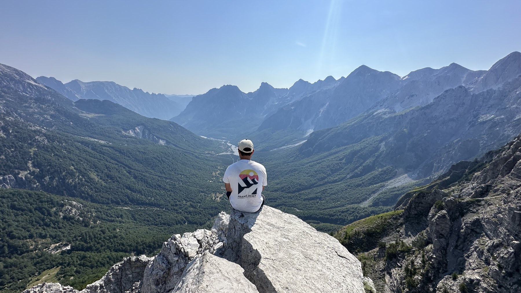 Kevin sitting on a rock above the Valbona Valley on the Valbona to Theth hike, Albania