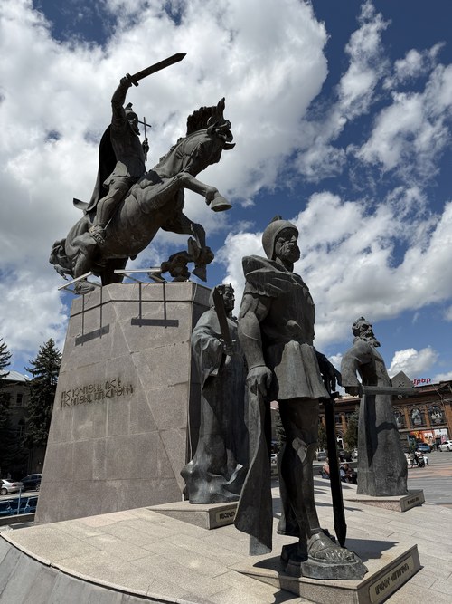 A bronze equestrian statue of a sword-wielding warrior above armored soldier figures, Vardanants Square, Gyumri, Armenia