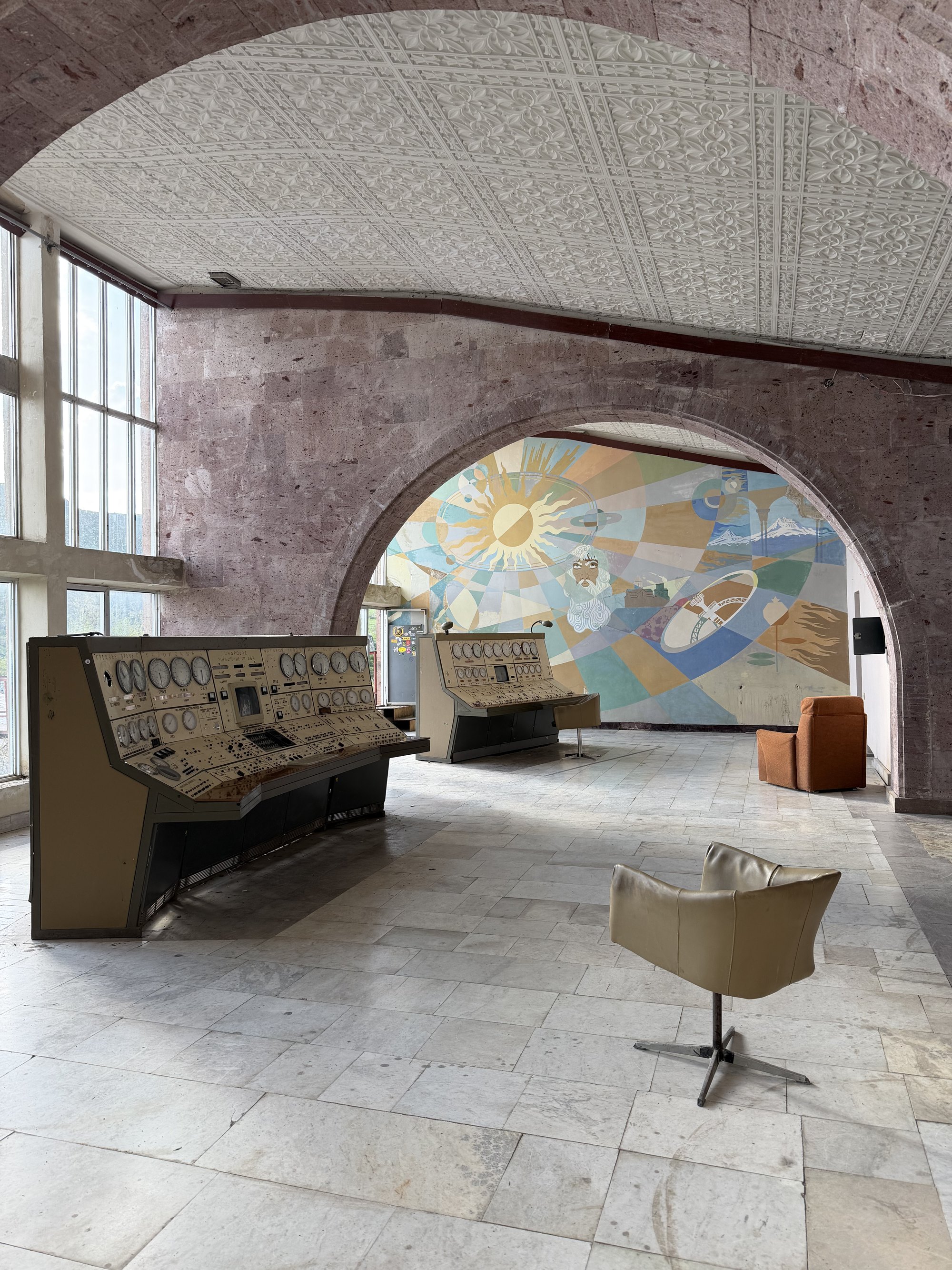 Soviet-era control consoles and a pastel space mural inside the abandoned Orgov Observatory, Armenia