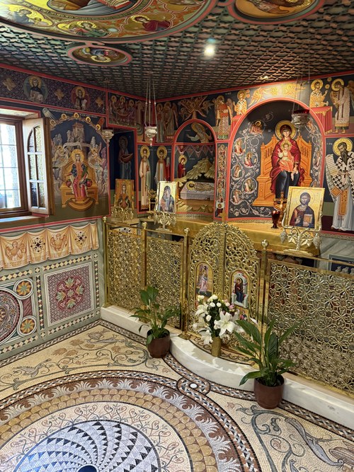 Gold lattice screen, painted icons and mosaic floor inside a small chapel with frescoed walls, Roussanou, Greece