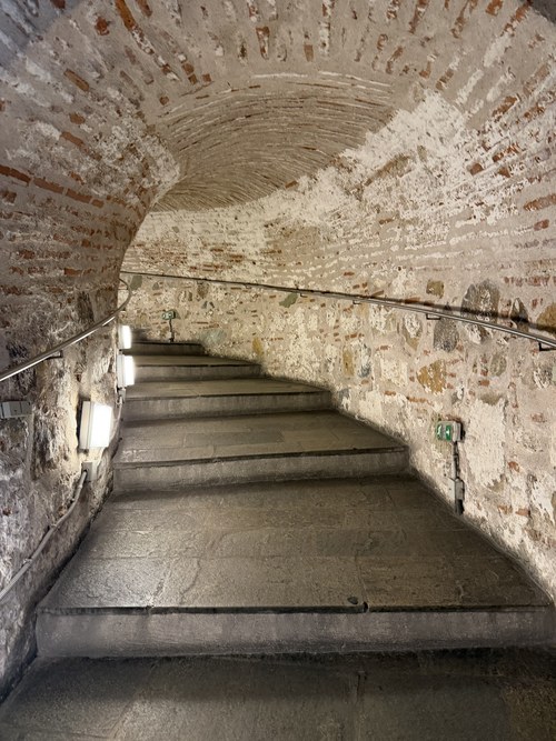 A curving stone staircase inside a vaulted brick passage, White Tower of Thessaloniki and Museum, Greece