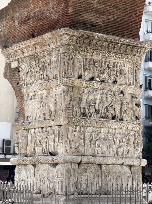 Close view of the arch's marble pier with tiers of carved relief figures and pigeons, Arch of Galerius, Greece