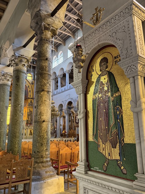 A gold mosaic icon of a saint beside marble columns inside the basilica, Holy Church of St. Demetrius, Greece