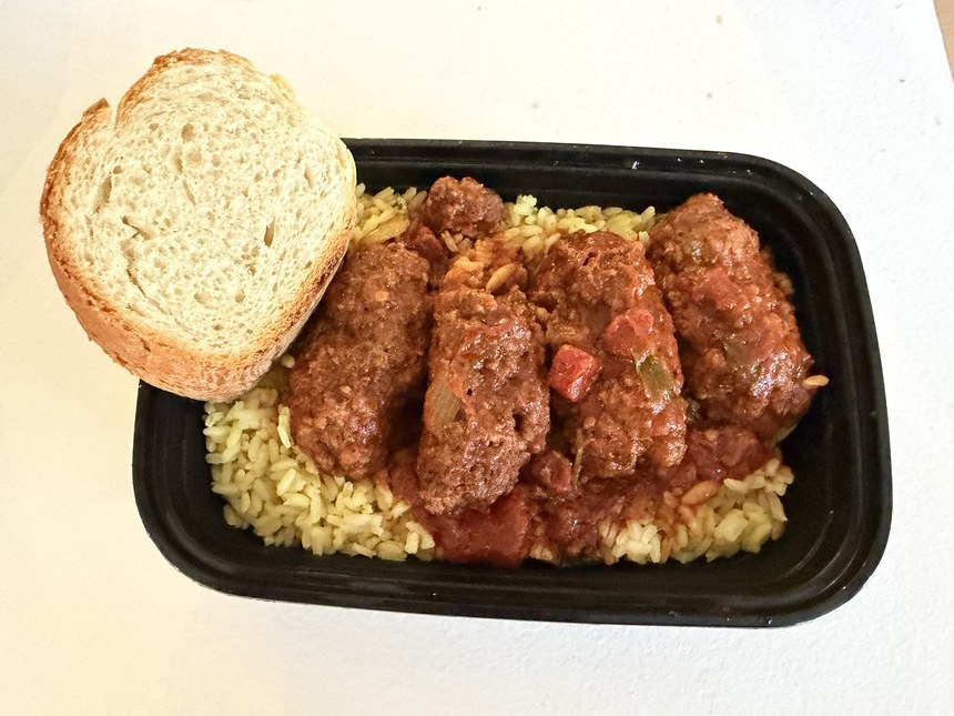 Baked meatballs in tomato sauce over yellow rice in a takeout container with a slice of bread, Hagia Sophia station, Greece