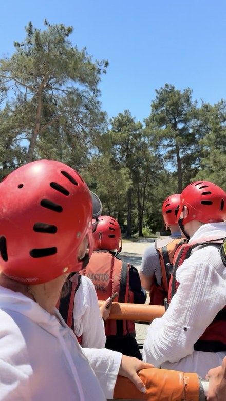 Rafters in red helmets and life jackets standing in an open jeep on the way through the pine forest, Köprülü Canyon, Turkiye