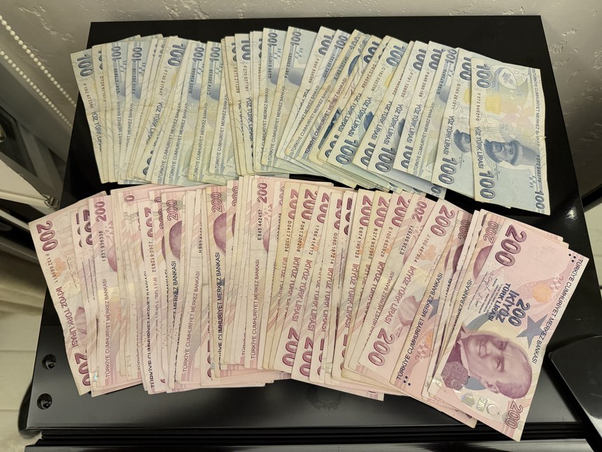 Stacks of Turkish lira banknotes, 200 and 100 lira bills fanned out on a black table, Kiana Kaleiçi, Turkiye