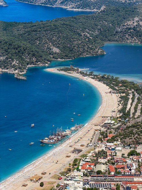 The Blue Lagoon, the beach and moored gulets at Ölüdeniz seen from high on the mountainside, Turkiye